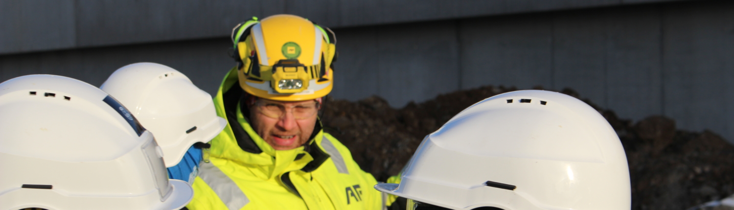 Instruktør forklarer elever om byggeplassen.